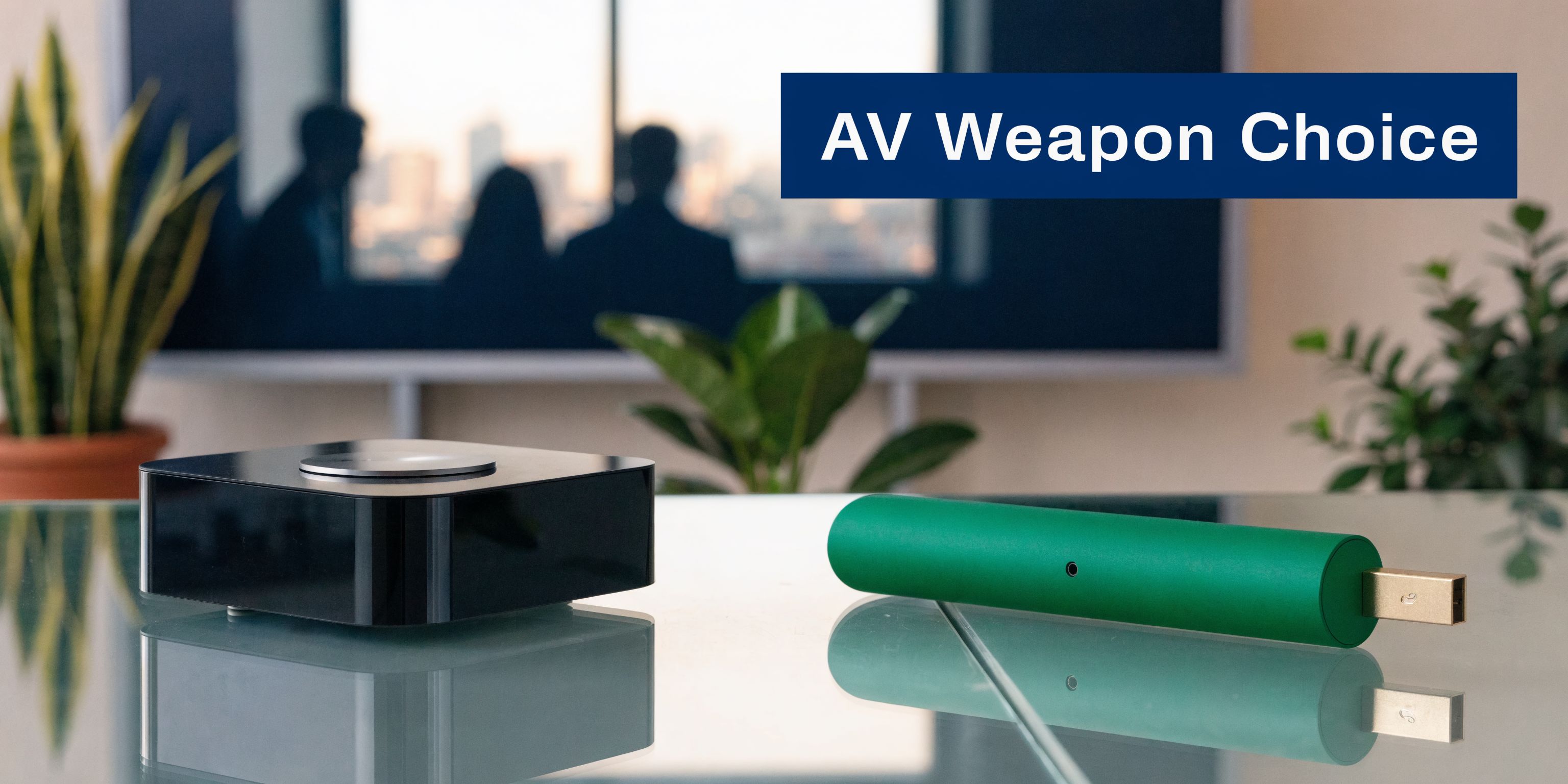 A sleek black streaming media player and a green USB drive sit on a glass office table.