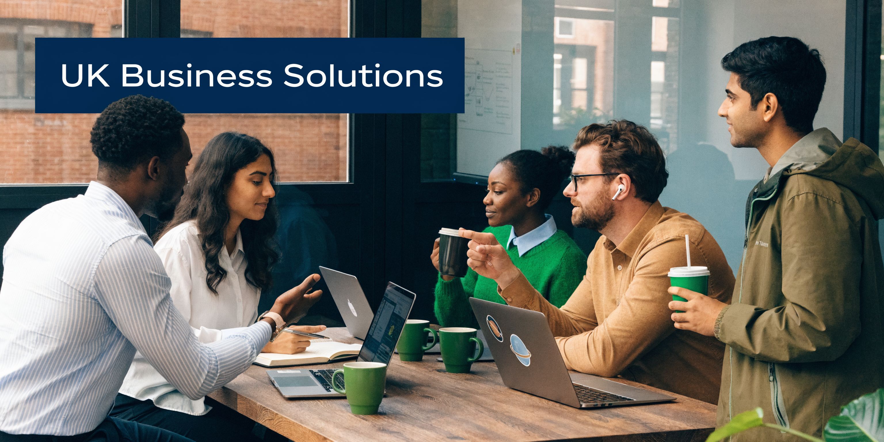 A diverse group of professionals collaborating on a business project around a wooden meeting table.