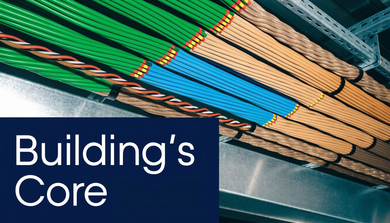 An organized group of electrical and data cables neatly arranged within a metal cable tray system.