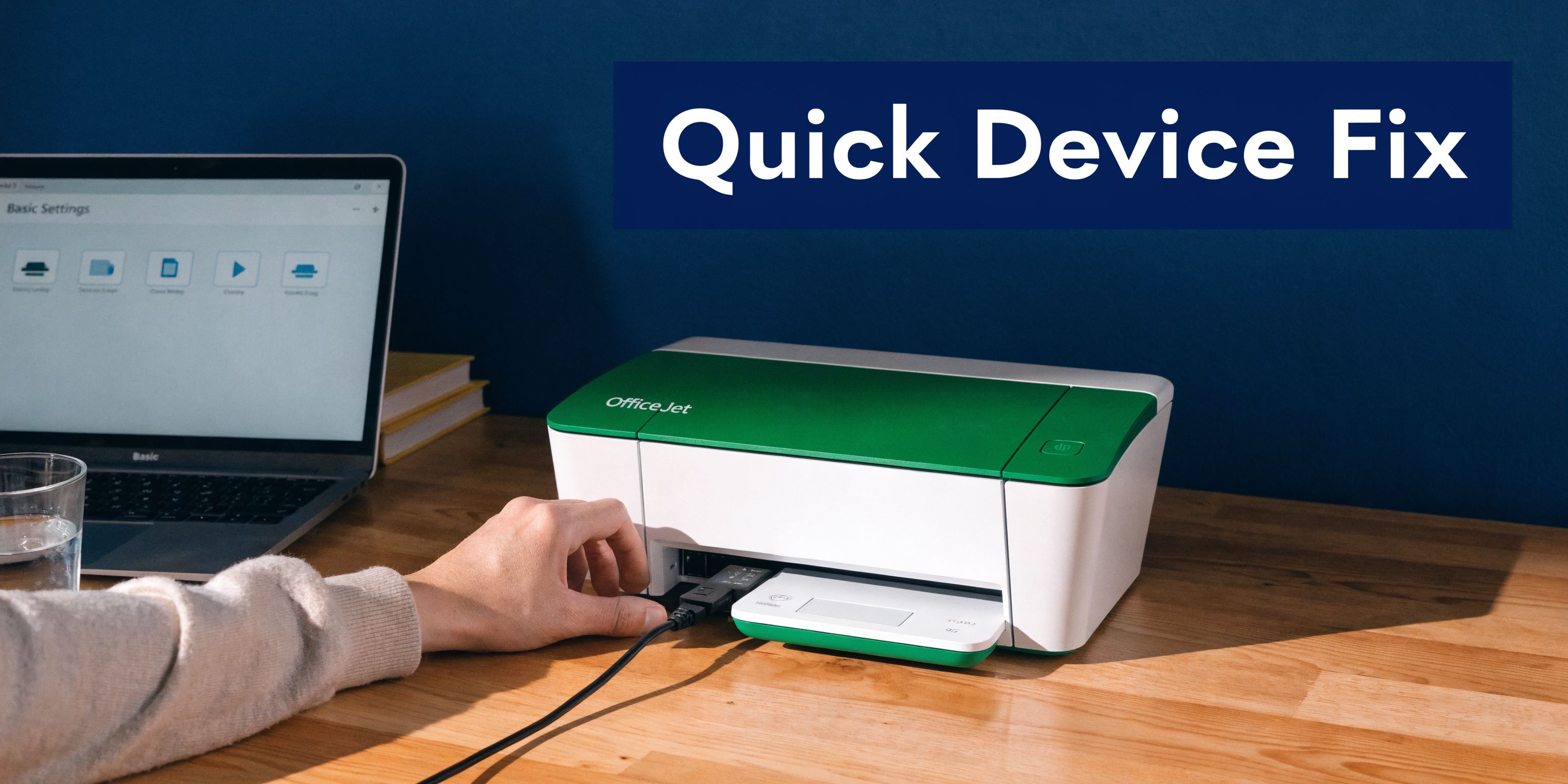 A person connecting a USB cable to a green and white OfficeJet printer on a wooden desk.