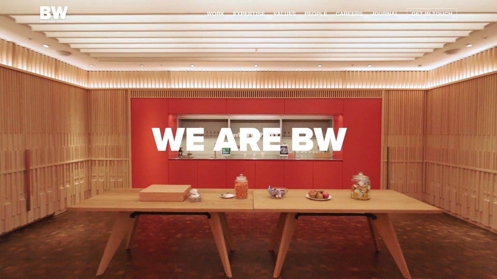 A bright office space designed by BW: Workplace Experts, with collaborative seating and modern lighting fixtures.